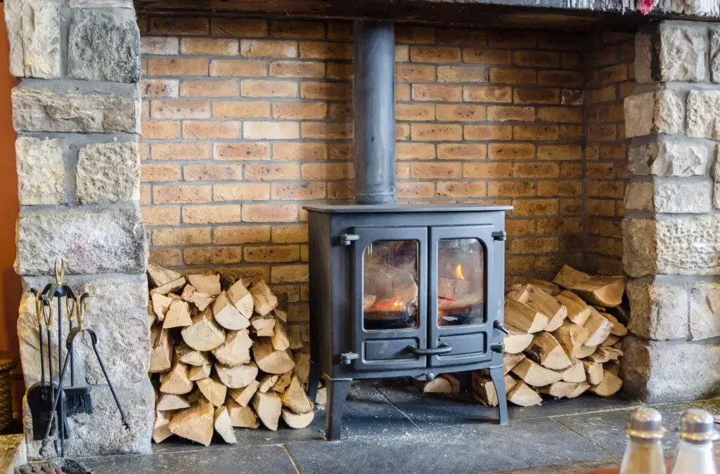 kiln dried wood logs by the side of a stove